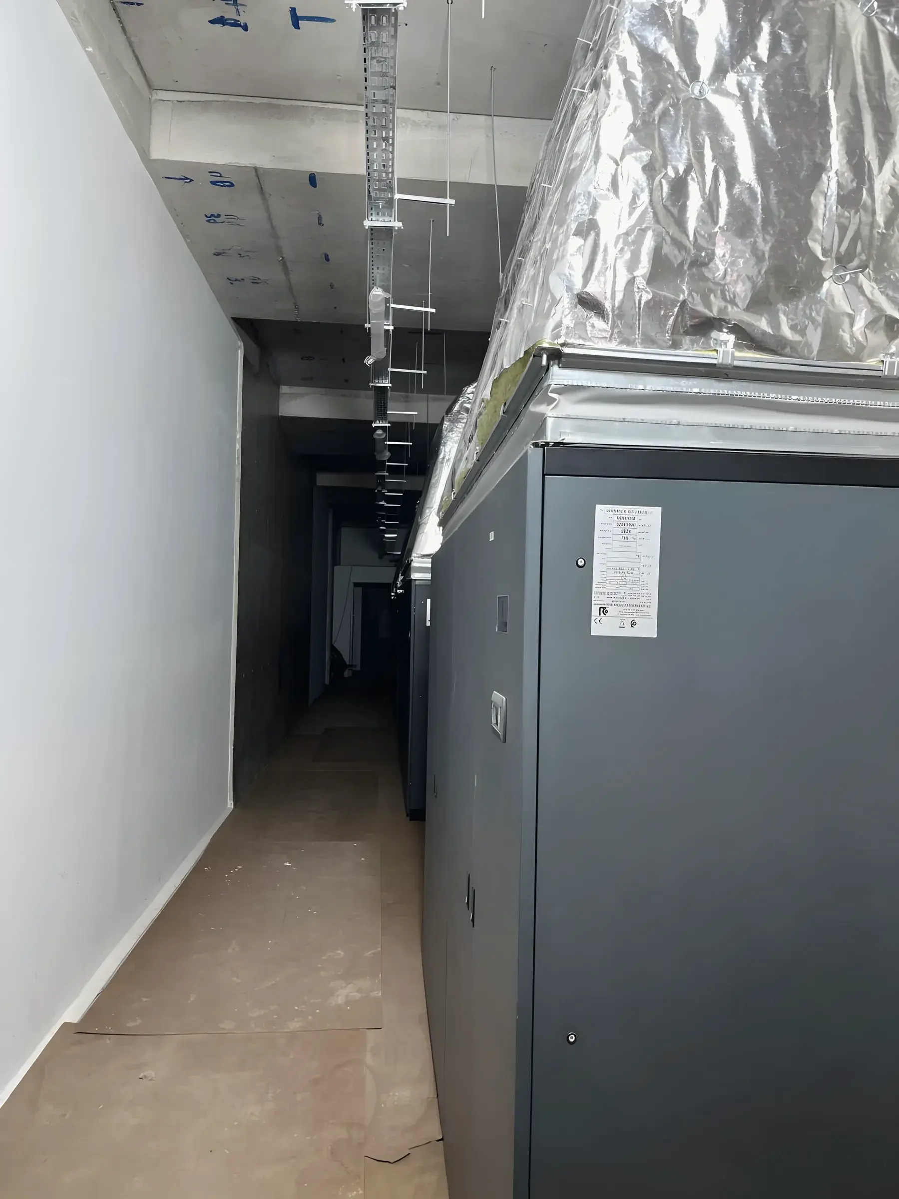 Computer room air handling units with insulated ductwork in a service corridor