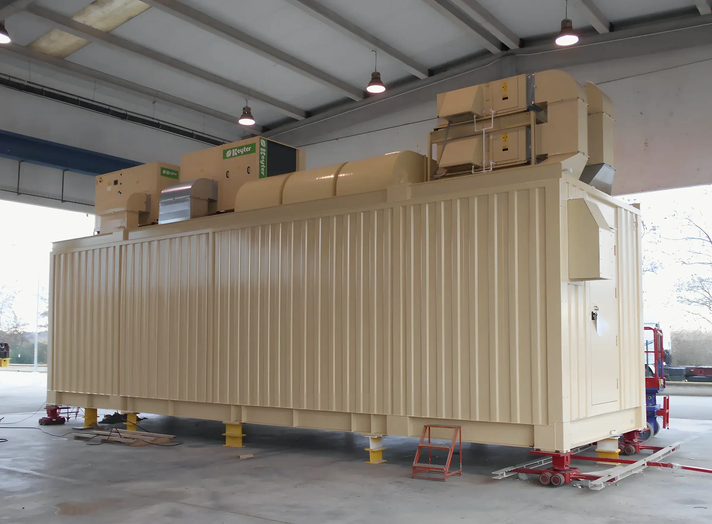 A prefabricated power module on jacks inside a factory hall, ready for acceptance testing