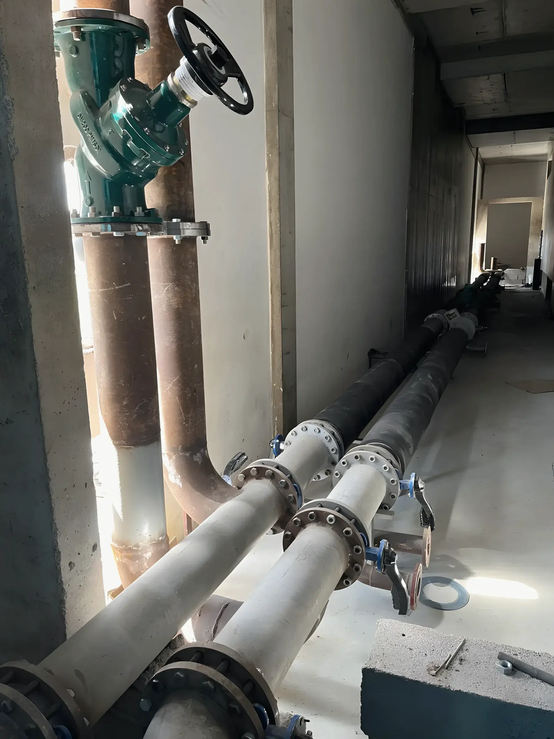 Chilled-water risers with isolation and balancing valves in a plant corridor